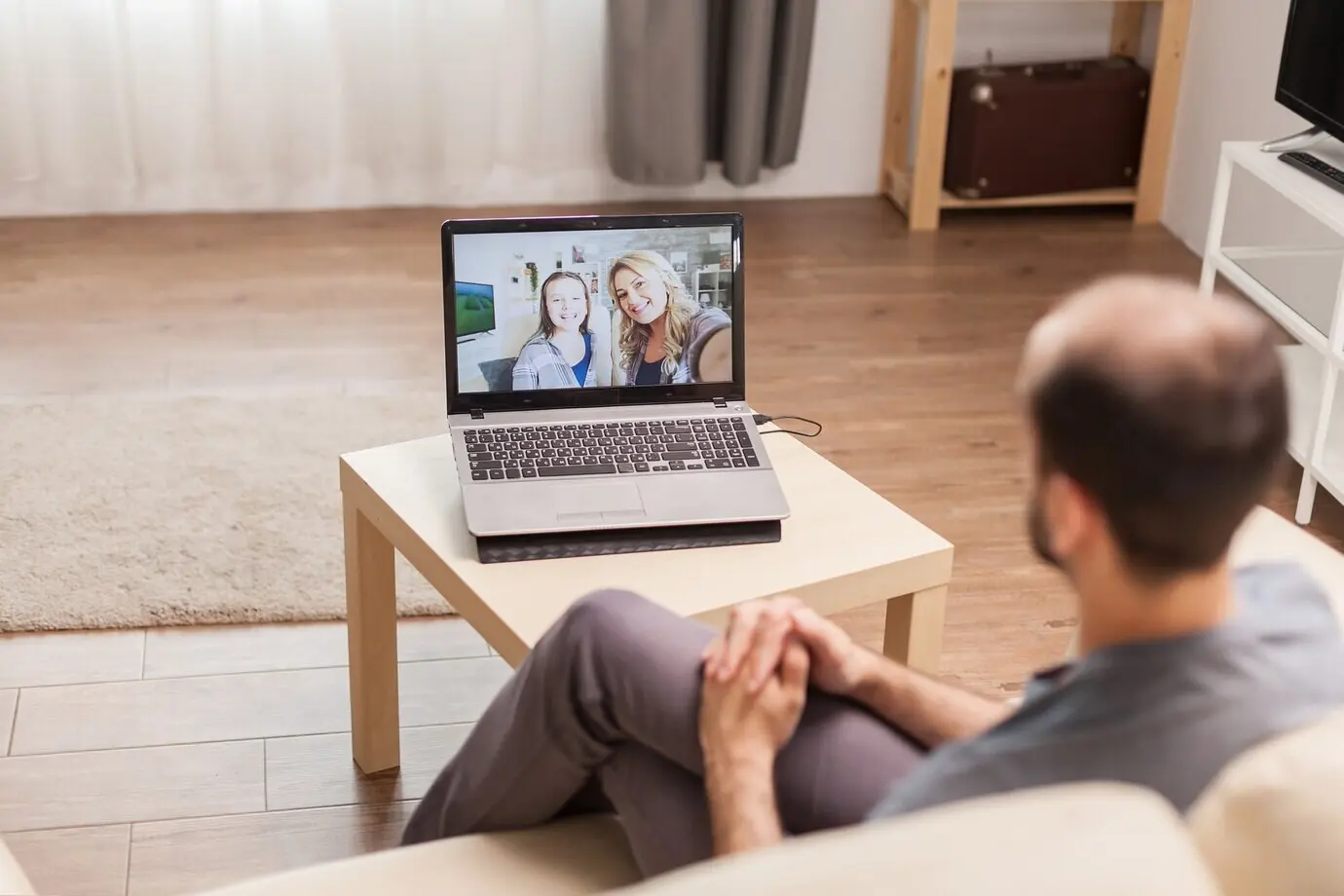 A man talking with his family over a video call during the global pandemic.